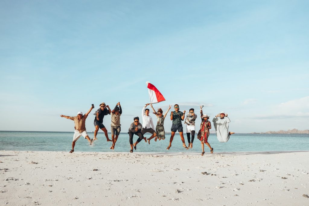 Indonesian people jumping together on the beach